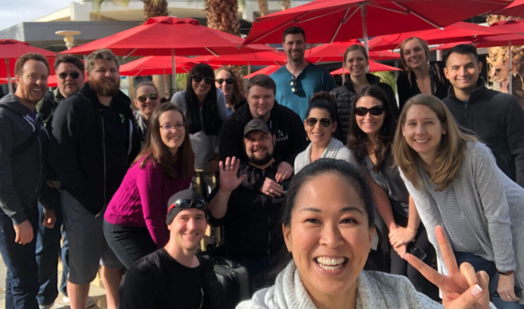 Group selfie of Kanopians with red umbrellas in background after the Kanopi retreat