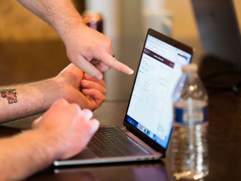 Hands pointing to a laptop
