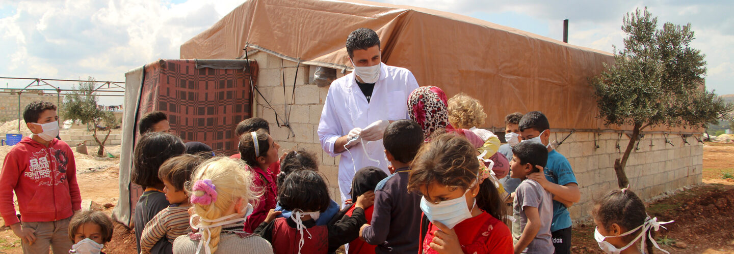 A Syrian medic gives instructions about the dangers of the spread of the coronavirus and distributes masks in a camp for displaced people near the Syrian town of Batabu in Syria's rebel-held northwestern Idlib province on March 17, 2020. (Photo by Ibrahim YASOUF / AFP) (Photo by IBRAHIM YASOUF/AFP via Getty Images)