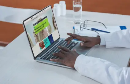 A doctor looks at a healthcare website on a laptop