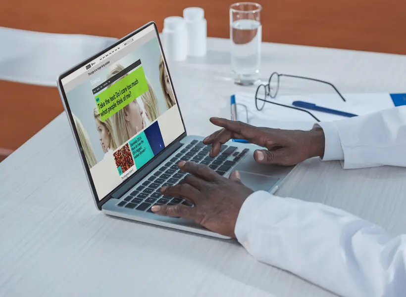 A doctor looks at a healthcare website on a laptop