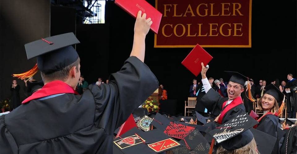 Flager students celebrating graduation with their diplomas
