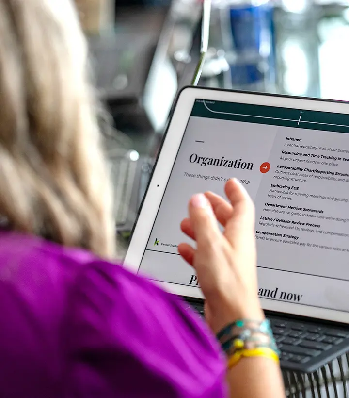 Close up of a tablet with a page up that says "organization" with a woman's hand in front of the screen