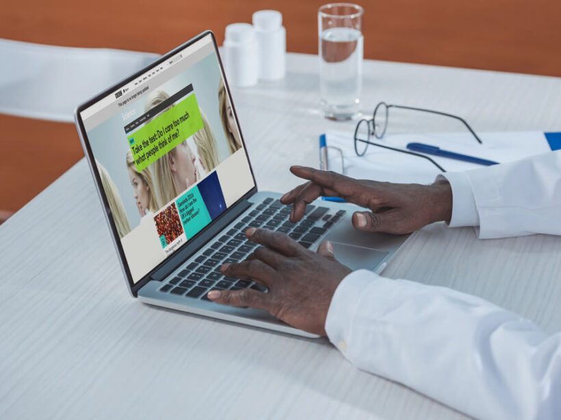 A healthcare professional uses a healthcare website on a laptop