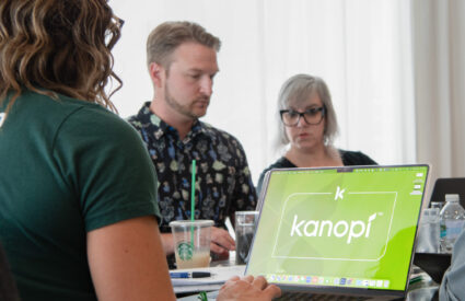 A team works around a table on laptop computers