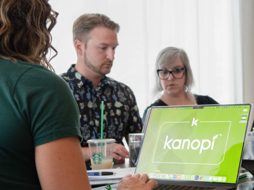 A team works around a table on laptop computers