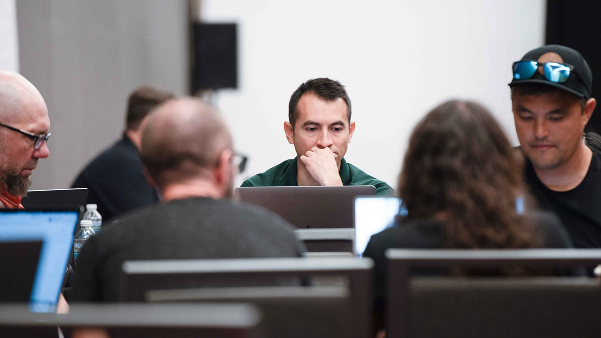 A focused Kanopi Studios team working together on laptops during a collaborative strategy session, developing digital solutions and creative strategies for clients.