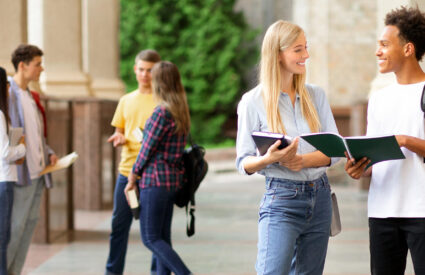 Two college students talking outside of an academic building