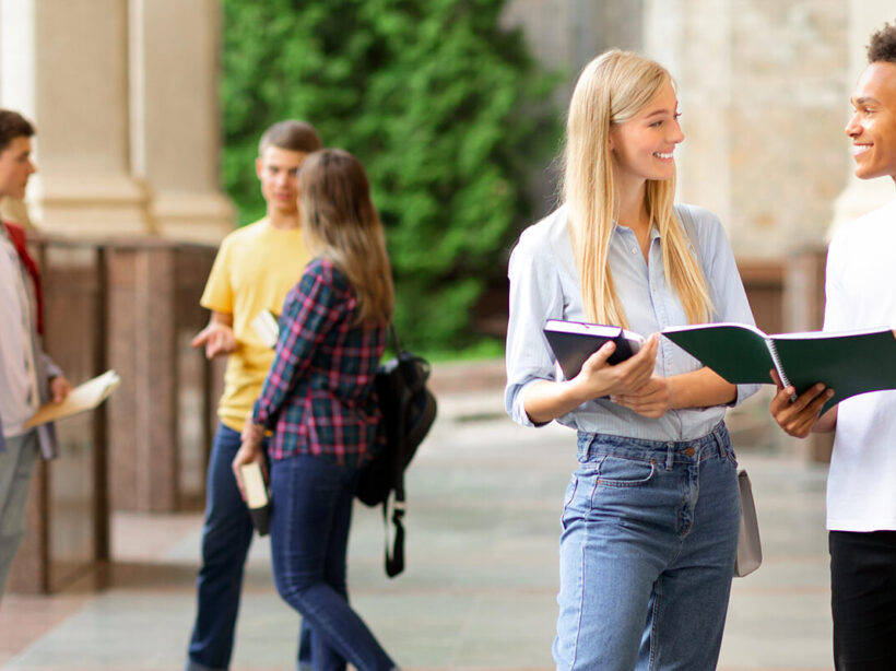 Two college students talking outside of an academic building